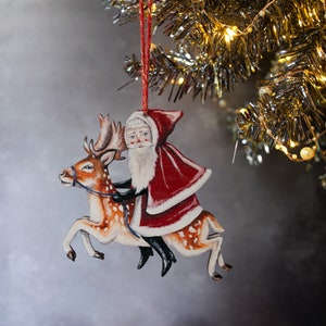 Father Christmas on a reindeer Christmas decoration, made from laser cut wood. Double sided, made in the UK