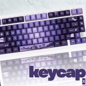 May include: A custom keyboard with purple keycaps. The keycaps have a gradient colour scheme and feature unique designs, including a spiderweb, a ghost, and a landscape scene. The word "keycap" is displayed in purple.