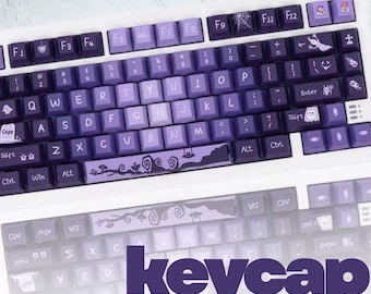 Op de afbeelding: Een aangepast toetsenbord met paarse keycaps. De keycaps hebben een kleurenschema met verloop en hebben unieke ontwerpen, waaronder een spinnenweb, een spook en een landschap. Het woord "keycap" wordt in het paars weergegeven.