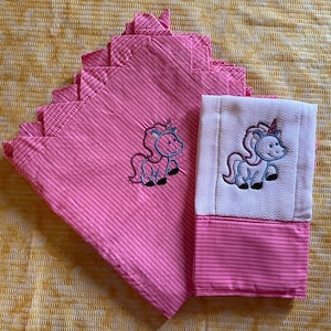 May include: Two pink and white striped fabric burp cloths with embroidered unicorn designs. The cloths are folded and stacked on top of each other.