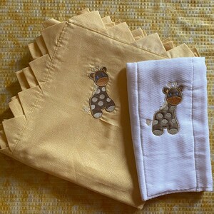 May include: Two baby blankets, one yellow with a giraffe design and one white with a giraffe design.