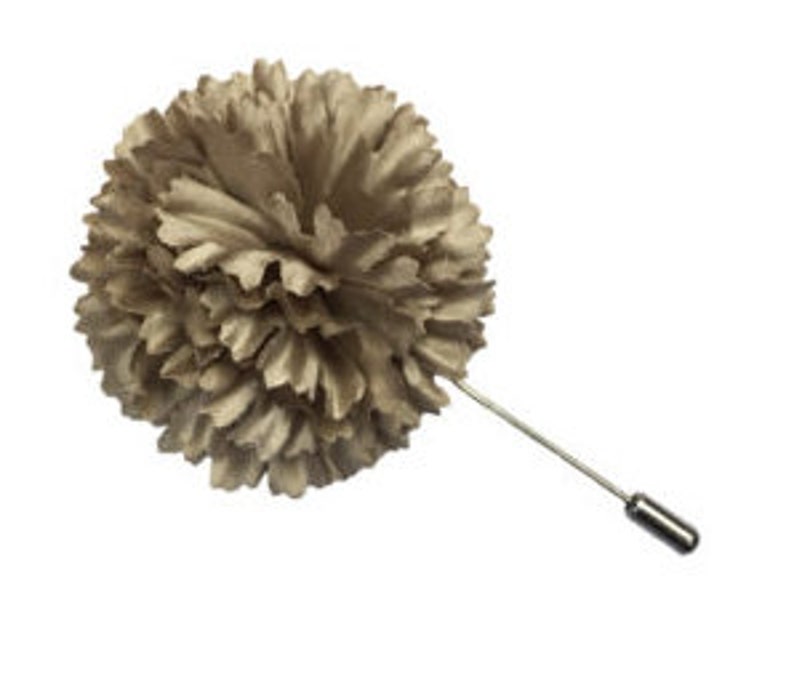 May include: A beige fabric flower lapel pin with a silver pin.