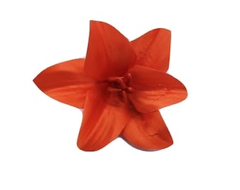 May include: A single orange silk lily flower.