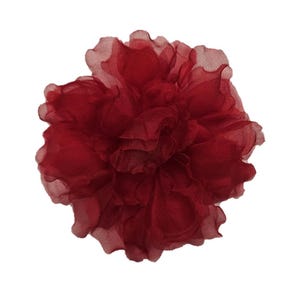May include: A large, red, fabric flower with a ruffled texture. The flower is made of a sheer material and has a delicate, feminine look.