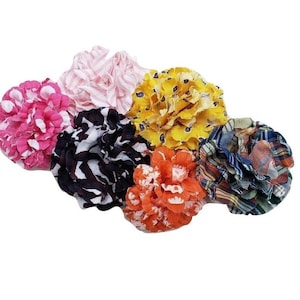 May include: Six fabric flower hair clips in various colours and patterns, including pink, yellow, orange, black, and blue.