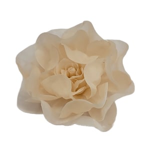 May include: A large, cream-colored paper flower with multiple layers of petals.