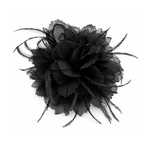 May include: A black floral accessory featuring layered, semi-sheer fabric petals arranged in a circular bloom. The design is accented with thin, wispy black feathers that extend outward from the center, creating a textured and dimensional appearance.