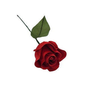 May include: A single red rose with a green leaf. The rose is made of fabric and has a realistic appearance.