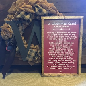 Peut inclure: Une impression encadr&eacute;e d'un extrait de A Christmas Carol de Charles Dickens. L'impression pr&eacute;sente un fond rouge avec du texte blanc. Le texte se lit comme suit : "Running to the window, he opened it, and put out his head. No fog, no mist; clear, bright, jovial, stirring, cold; cold, piping for the blood to dance to; Golden sunlight; Heavenly sky; sweet fresh air; merry bells. Oh, glorious! Glorious! "What's today?", cried Scrooge, calling downward to a boy in Sunday clothes, who perhaps had loitered in to look about him. "Eh?", returned the boy, with all his might of wonder. "What's today, my fine fellow?", said Scrooge. "Today?", replied the boy. "Why, Christmas day." It's Christmas day!", said Scrooge to himself. "I haven't missed it." 110.