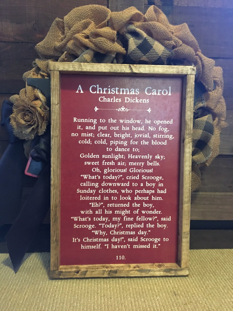 Peut inclure: Une pancarte en bois rouge avec du texte blanc qui dit "A Christmas Carol" de Charles Dickens. Le texte continue avec un extrait du livre, d&eacute;crivant une sc&egrave;ne d'un matin de No&euml;l lumineux et froid.