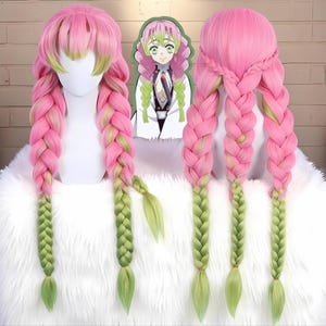 May include: A pink and green cosplay wig with long, braided pigtails. The wig features a blend of pink and green colors, with the braids transitioning to a lighter green at the ends. A character illustration is visible in the background.