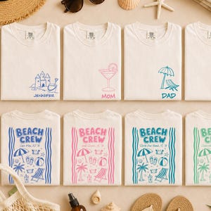 May include: Eight white t-shirts arranged in two rows. The top row features small chest graphics of a sandcastle, cocktail, beach chair, and snorkel with names. The bottom row displays large Beach Crew designs with beach icons and location text.