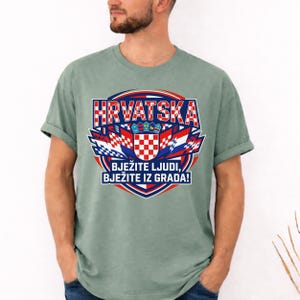 Moss premium garment-dyed t-shirt with a bold Croatian national shield and football team spirit print, shown on a bearded male model.
