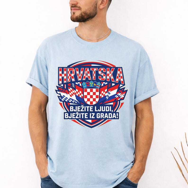 May include: Light blue t-shirt with a Croatian flag design. The graphic includes the word "HRVATSKA" in red and white, along with the Croatian coat of arms and the text "BJEŽITE LJUDI, BJEŽITE IZ GRADA!"