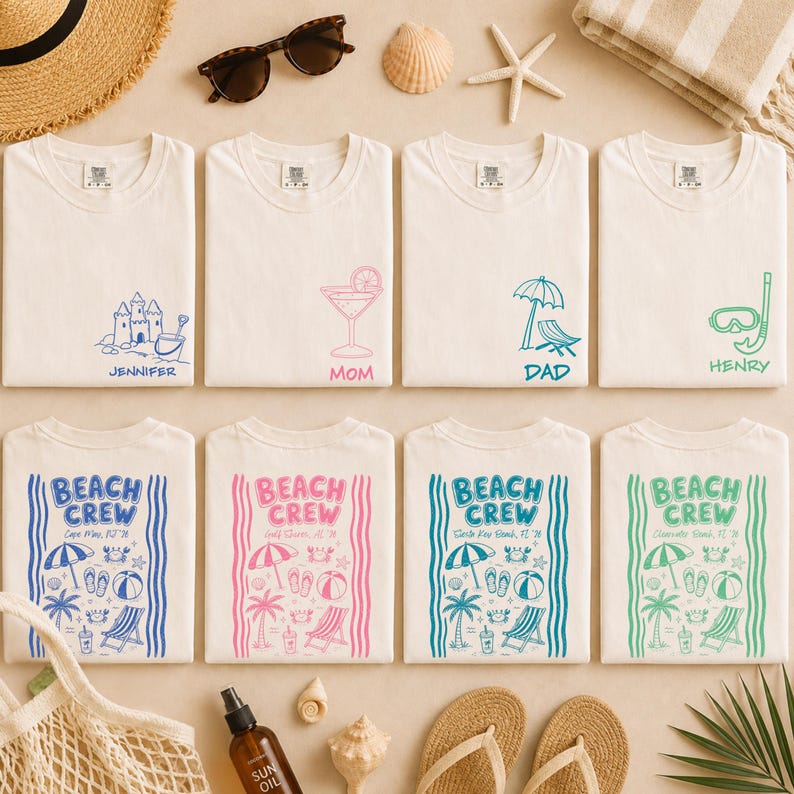 May include: Eight white t-shirts arranged in two rows. The top row features small chest graphics of a sandcastle, cocktail, beach chair, and snorkel with names. The bottom row displays large Beach Crew designs with beach icons and location text.