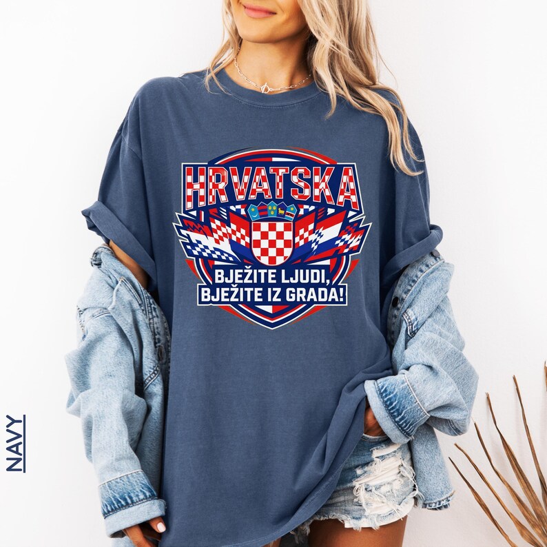 Navy blue oversized graphic tee showcasing Croatia national team colors and sports banner design, styled with a denim jacket on a smiling female model.