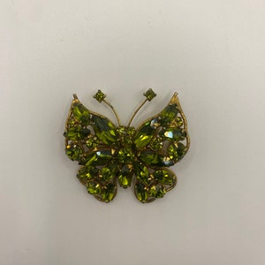 May include: A gold-tone butterfly brooch with green rhinestones.