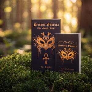 May include: A black tarot card box and a matching guidebook, both featuring gold foil illustrations of an ornate mask and the text Persona Obscura The Gothic Tarot. The box is labeled 78 Cards, while the book is labeled The Guidebook.