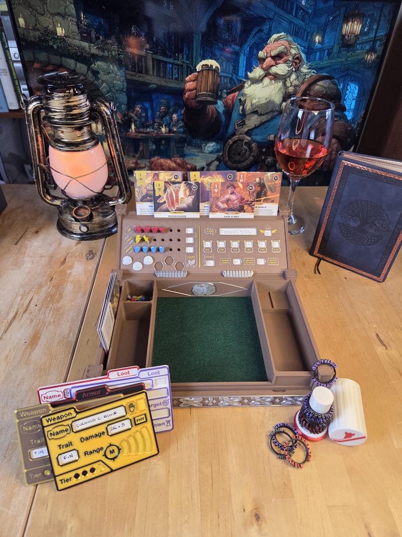 May include: A tabletop role-playing game setup featuring a wooden game board with a green felt surface, cards, dice, and tokens. A vintage oil lamp and a glass of red wine are also present. A fantasy art print hangs in the background.