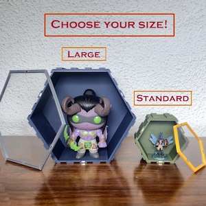 May include: Hexagonal display cases in two sizes, large and standard, with clear front panels. One case holds a purple figurine with horns and green eyes, the other a blue and green figurine. Text reads "CHOOSE YOUR SIZE!"