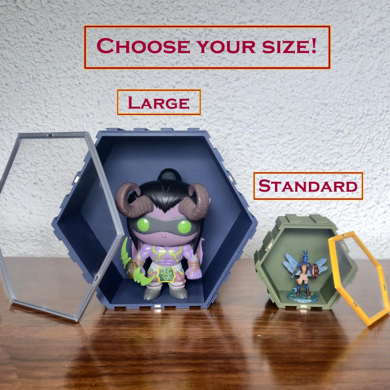 May include: Hexagonal display cases in two sizes, large and standard, with clear front panels. One case holds a purple figurine with horns and green eyes, the other a blue and green figurine. Text reads "CHOOSE YOUR SIZE!"
