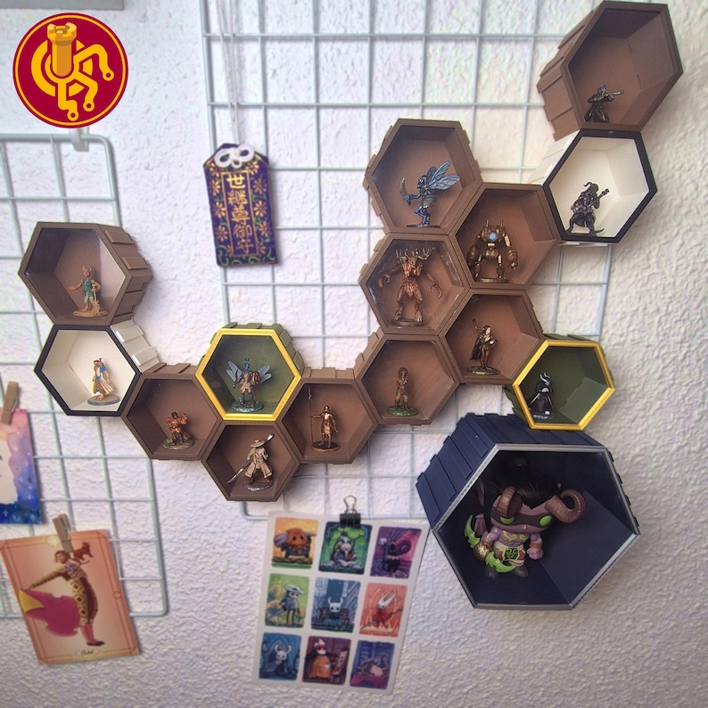 May include: A wall-mounted, hexagonal shelf unit in shades of brown, white, and gold, displaying miniature figurines. The shelves are arranged in a honeycomb pattern, with various fantasy figures inside. A collection of character art is clipped below.