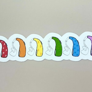 Può includere: Una fila di sette apparecchi acustici colorati con diversi motivi, tra cui fulmini, stelle e pois.
