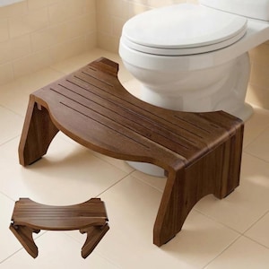 May include: A dark brown wooden bathroom stool with a curved, slatted top surface and two sturdy side supports. The stool features a cutout design along the front edge, allowing it to fit closely against the base of a white toilet.