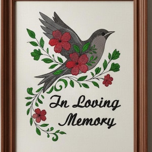 May include: A framed artwork featuring a gray bird with red flowers and green leaves. The words "In Loving Memory" are written in black script below the bird. The frame is made of brown wood.