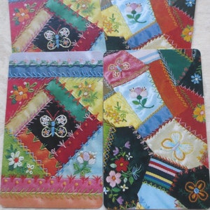 May include: Four colorful fabric squares with a patchwork design featuring butterflies and flowers. Each square has a different color scheme and pattern.