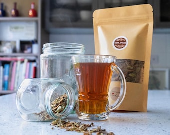 May include: A glass jar filled with dried herbs and spices, a glass mug filled with tea, and a brown paper bag with the text "A&M Spices" printed on it.