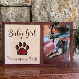 May include: Wooden photo frame with a paw print and a red heart, the text "Baby Girl Forever in our Hearts" is engraved on the frame. A photo of a brown dog is in the frame.