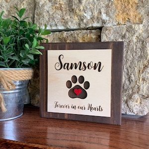 May include: Wooden sign with a paw print and a red heart in the center. The sign reads "Samson Forever in our Hearts".