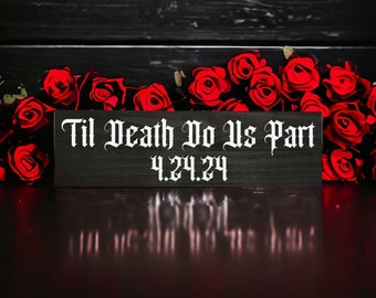 May include: Black wooden sign with white text that reads "Til Death Do Us Part 4.24.24". The sign is surrounded by red roses.