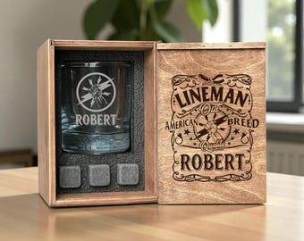 May include: A personalized whiskey glass with the name "Robert" and a lineman graphic, presented in a wooden box. The box also features the text "Lineman Old Breed American Quality Robert" and includes three whiskey stones.