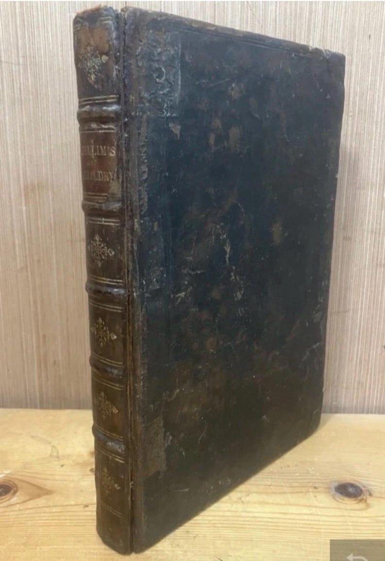 May include: An antique book with a dark leather cover and spine. The spine is brown with gold lettering and decorative accents. The book's pages are aged, and the overall appearance suggests it is a vintage item.