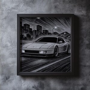 May include: Black and white framed print of a sports car speeding down a road at night. The artwork features a detailed illustration of the car with city buildings and streetlights in the background. The print is mounted in a black frame.