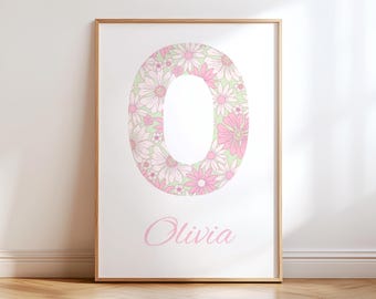 Puede incluir: Un estampado enmarcado con la letra "O" llena de flores rosas y blancas similares a margaritas. El nombre "Olivia" está escrito en una delicada escritura rosa debajo. El marco es de color marrón claro.