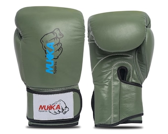 May include: Two olive green boxing gloves. The gloves have a white wrist strap with the text "MUKKA Sports" and a fist graphic. The brand name "MUKKA" is also printed on the side of the glove in blue and white.