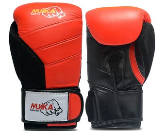 May include: Pair of red and black boxing gloves with the brand name "NUKKA Sports" printed on the wrist straps. The gloves have a red top and black palm and wrist areas. The gloves are designed for boxing or other combat sports.