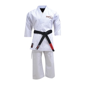 Puede incluir: Uniforme de karate blanco con cinturón negro y detalles rojos. El uniforme incluye una chaqueta con la palabra "MUKA" en letras rojas y pantalones a juego. El cinturón negro tiene rayas rojas en los extremos.