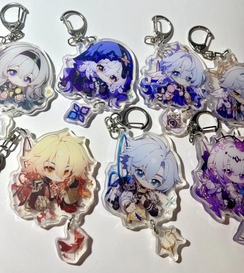 K&ouml;nnte beinhalten: Eine Sammlung von Anime-Acryl-Schl&uuml;sselanh&auml;ngern mit verschiedenen Charakteren. Jeder Schl&uuml;sselanh&auml;nger hat einen silberfarbenen Metallverschluss. Die Charaktere haben detaillierte Designs mit leuchtenden Farben, darunter Blau, Lila und Gold. Die Schl&uuml;sselanh&auml;nger sind transparent mit gl&auml;nzendem Finish.