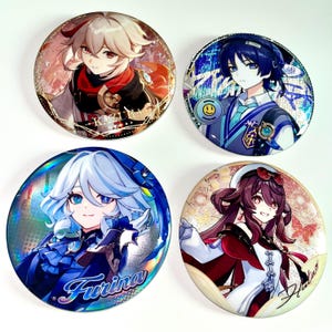 Pu&ograve; includere: Quattro distintivi rotondi con personaggi. I distintivi presentano illustrazioni colorate di personaggi anime. I personaggi hanno vari colori di capelli e indossano abiti dettagliati. I distintivi sono su una superficie bianca.