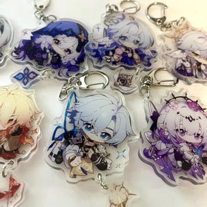 K&ouml;nnte beinhalten: Eine Sammlung von Anime-Stil-Schl&uuml;sselanh&auml;ngern aus Acryl, die verschiedene Charaktere zeigen. Jeder Schl&uuml;sselanh&auml;nger hat einen silbernen Verschluss und ein detailliertes, farbenfrohes Design. Die Charaktere haben gro&szlig;e Augen und sind in dynamischen Posen, mit blauen, lila und goldenen Akzenten.