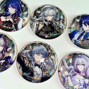 Puede incluir: Un conjunto de botones redondos y metálicos con ilustraciones de personajes de estilo anime. Cada botón tiene un efecto holográfico e incluye nombres de personajes y el texto "STAR RAIL LIVE". Los personajes tienen varios colores de pelo y atuendos.