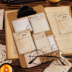 Może przedstawiać: Kolekcja notatek i kart papierowych w stylu vintage z tekstami takimi jak "Record Fragment" i "Don't Forget to Do". Karty ułożone są na tablicy i stronach starych książek, z okrągłymi okularami. Paleta kolorów jest ciepła i postarzała.