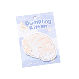 Puede incluir: Un paquete de notas adhesivas "Dumpling Kitten". Las notas tienen forma de gato y presentan una combinaci&oacute;n de colores naranja claro y blanco. El embalaje azul claro incluye el texto "Dumpling Kitten" y "cute cat".