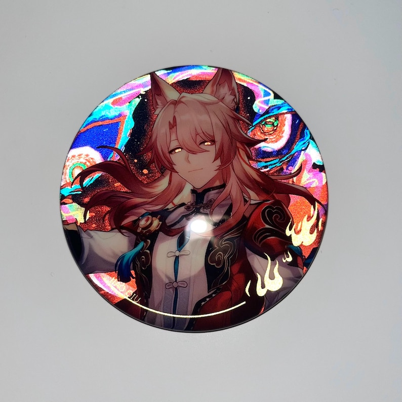 May include: A round, iridescent button featuring a character with pink hair and fox ears. The character is wearing a red and gold outfit with a blue sash. The background is a swirling pattern of blue, green, and red.