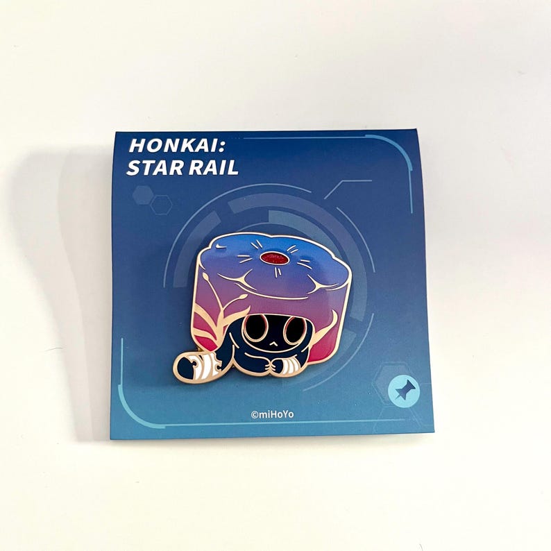May include: A pin featuring a stylized character from "Honkai: Star Rail." The pin has a blue, purple, and red color scheme. The pin is on a blue card with the game's title and the copyright information.