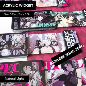 Könnte beinhalten: Acryl-Widgets mit Illustrationen im Anime-Stil. Jedes Widget misst 13,2 cm lang, 5,1 cm breit und 1,3 cm dick. Die Designs umfassen Charaktere und Text, mit einem rosa und schwarzen Farbschema.